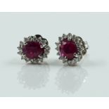 A PAIR OF WHITE GOLD, RUBY AND DIAMOND OVAL CLUSTER EARSTUDS