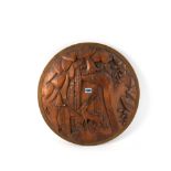 AN ART DECO CARVED WOODEN CONVEX CIRCULAR PLAQUE