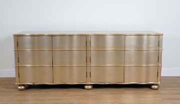 PAUL MARTIN; A GOLD PAINTED WAVY FRONTED FOUR DOOR LOW CABINET