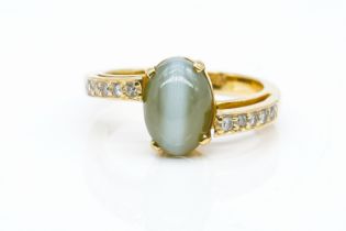 A GOLD, SYNTHETIC CHRYSOBERYL CAT'S EYE AND DIAMOND RING