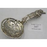 A continental silver sifter spoon. The handle of a man playing the bag pipes. Import marks for