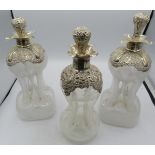 A set of three Edwardian silver mounted pinched glass decanters with original silver mounted