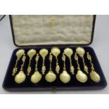 A set of 12 gilded teaspoons with shell bowl and figural terminal standing on a dolphin. 3 fully