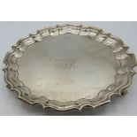 A silver salver with pie crust edge on 3 feet. Monogramed centre. Sheffield 19156 Walker & Hall.