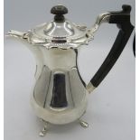A silver hot water jug on pad feet. Ebonised handle & finial, approx 8" high, Birmingham 1939.