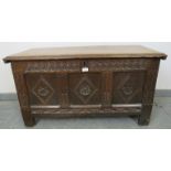 A 17th century panelled oak coffer of small proportions, with relief carved frieze and diamond