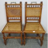 A pair of Edwardian medium oak hall chairs featuring carved lion finials and turned spindles, with