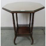 An Edwardian mahogany octagonal two-tier occasional table, featuring arcaded gallery, on outswept