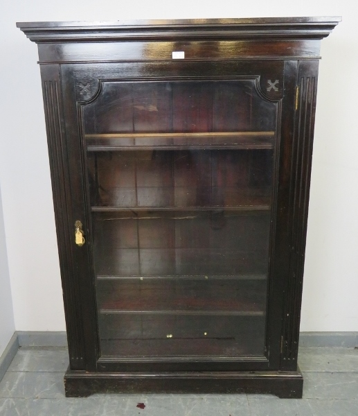 A Victorian mahogany ebonised glazed bookcase, flanked by reeded columns, housing four height