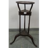 An Edwardian mahogany Georgian Revival wig stand, with dished top and reeded decoration, on three