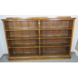 A large Victorian Gothic Revival medium oak low open bookcase of six height adjustable shelves, on a