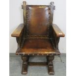 A 19th century oak Jacobean Revival armchair, upholstered in burgundy leather with large brass
