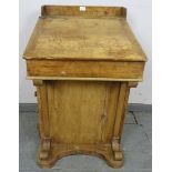 A Victorian pine Davenport, the lid opening onto a fitted interior, above four long drawers and four