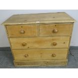 A small Victorian stripped pine chest of two short over two long drawers with turned wooden knob