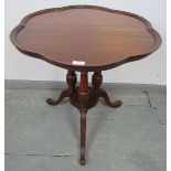 An Edwardian mahogany Regency Revival occasional table, with shaped edge, over fluted cluster