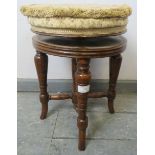 A turn of the century walnut height adjustable music stool, with tapestry seat, on turned tapering