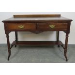 An Edwardian mahogany writing table, housing two short drawers with fancy brass handles, on tapering