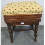 An Edwardian mahogany height adjustable music stool, re-upholstered in a gold patterned material, on
