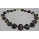An unusual graduated tourmaline necklace consisting of 19 flat round tourmaline discs interspersed