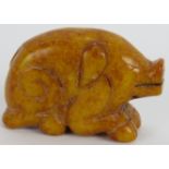 A charming Chinese carved amber-coloured Jade recumbent pig with black striations throughout, with