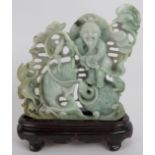 An intricate Chinese carved celadon Jade group of a fisherman catching fish, with russet and black