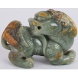 A Chinese carved celadon and russet Jade Dog of Fo, Ming style but likely Qing, 7cm long x 5cm high.
