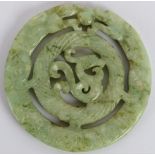 A Chinese carved black speckled celadon Jade disc, Ming style but likely Qing, 7cm diameter.