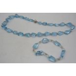 A blue topaz laser cut necklace interspersed with white metal beads with a 925 silver clasp.