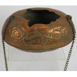 A small Middle Eastern copper Kashkul begging bowl with ornate chased decoration and chain handle.