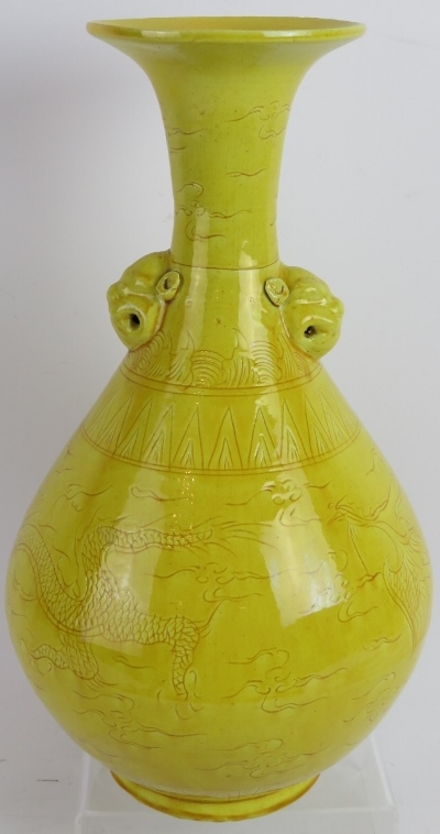A Chinese yellow porcelain baluster vase with incised underglaze decoration and lion mask handles.