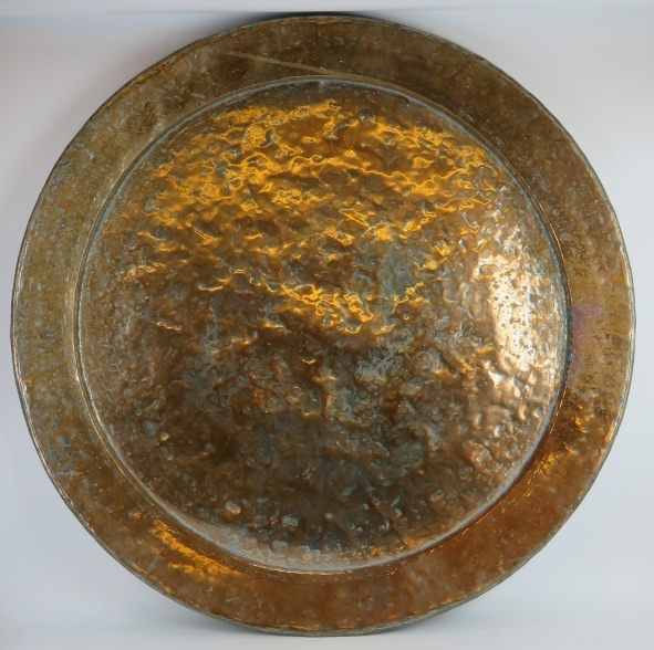 A very large antique Middle Eastern copper charger. 108 cm diameter, with remnants of silver over