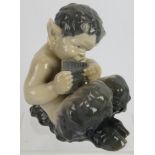 A Royal Copenhagen porcelain figure of a faun playing pan pipes. Model number: 1736. Height: 14cm.