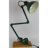 An EDL Industries 1930s articulated machinist's lamp in green, mounted on a wooden block.