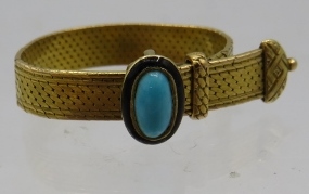 A yellow metal strap ring with turquoise coloured stone and black enamelling. 5grams. Condition