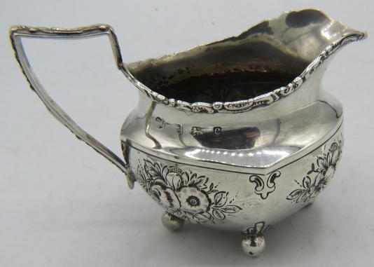 A pretty silver cream jug on ball feet. Embossed with flowers. Birmingham 1902. Thomas Hays. 3