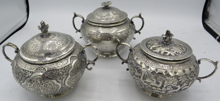A collection of Islamic white metal (probably silver) twin handled jars and covers, highly