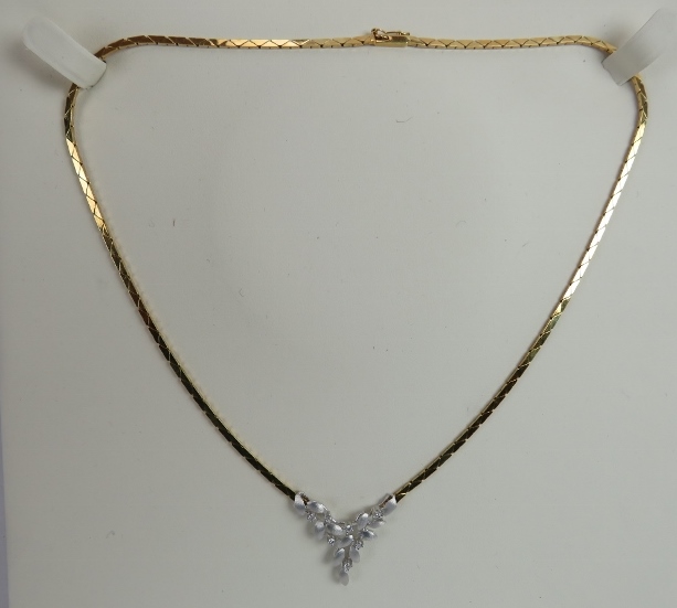 An 18ct yellow & white gold delicate necklace. The centre design having leaf decoration and set with