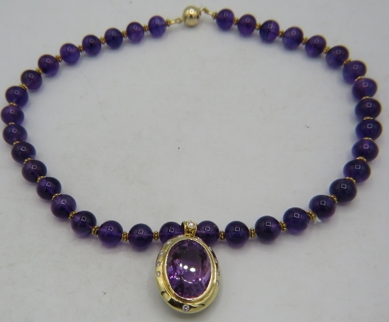 An 18ct yellow gold pendant set with large amethyst, approx 25mm x 18mm and surrounded by 12