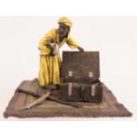 A Vienna Bergmann style cold painted bronze figure of an Arab arms trader on a rug. Width 13cm.