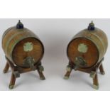 A pair of Edwardian coopered oak spirit barrels with silver plated mounts, similar stands and with