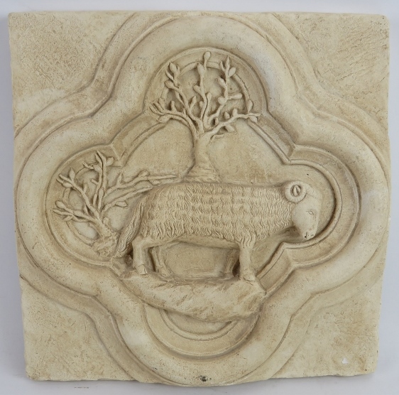 A plaster copy of a medieval stone quatrefoil end stone containing a sheep and olive trees. 29cm x