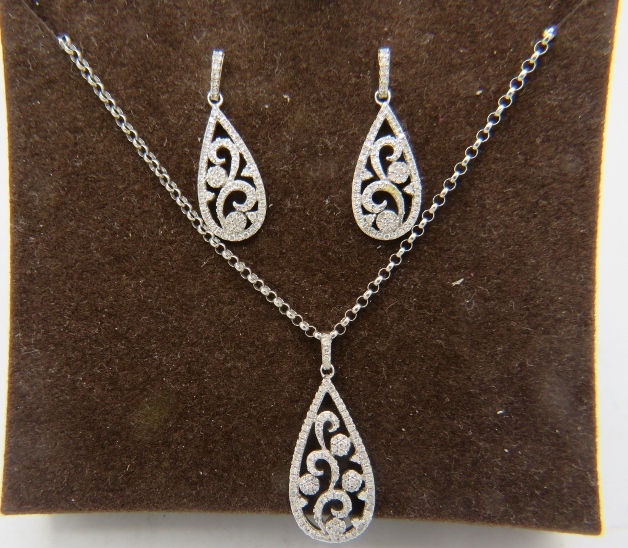 A fine pear shaped 9ct white gold pendant with openwork floral design encrusted with diamonds on a