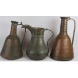 Two large beaten copper Middle Eastern water ewers and a large dallah coffee pot with detachable li