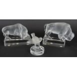 Three Lalique glass animals, to include a bull, a bison and a bird menu holder. All marked '