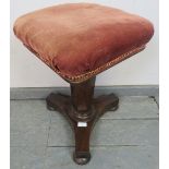 A Victorian rosewood square music stool upholstered in red corduroy material with gold braid, on a