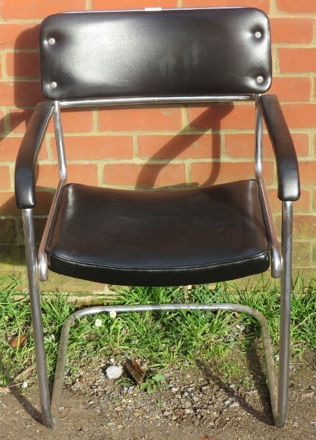 A vintage mid century cantilever chrome framed desk chair upholstered in a black vinyl material.