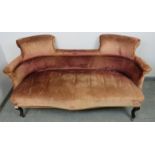 An Edwardian two-seater scroll-back sofa, upholstered in faded red antique velvet, with braided rope