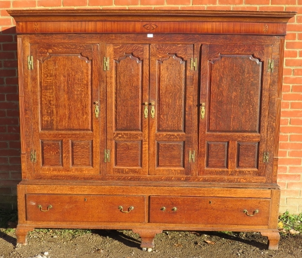 A good 18th century Welsh oak livery cupboard, the inlaid cornice featuring a central butterfly,