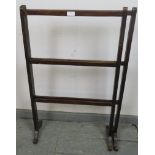 An Edwardian mahogany folding towel rail, on scrolled supports. H93 W101 D22 (approx). Condition
