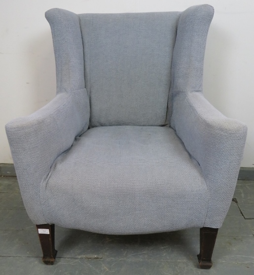 A Georgian wingback armchair of small proportions, reupholstered in orange material with a grey